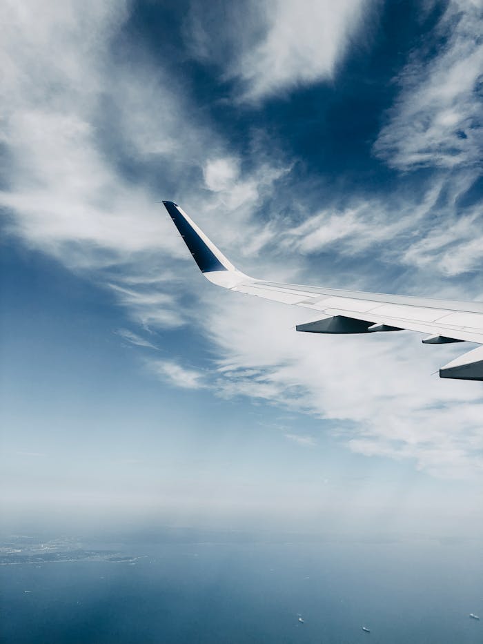 A scenic view of an airplane wing cruising above the clouds, capturing the serene sky.