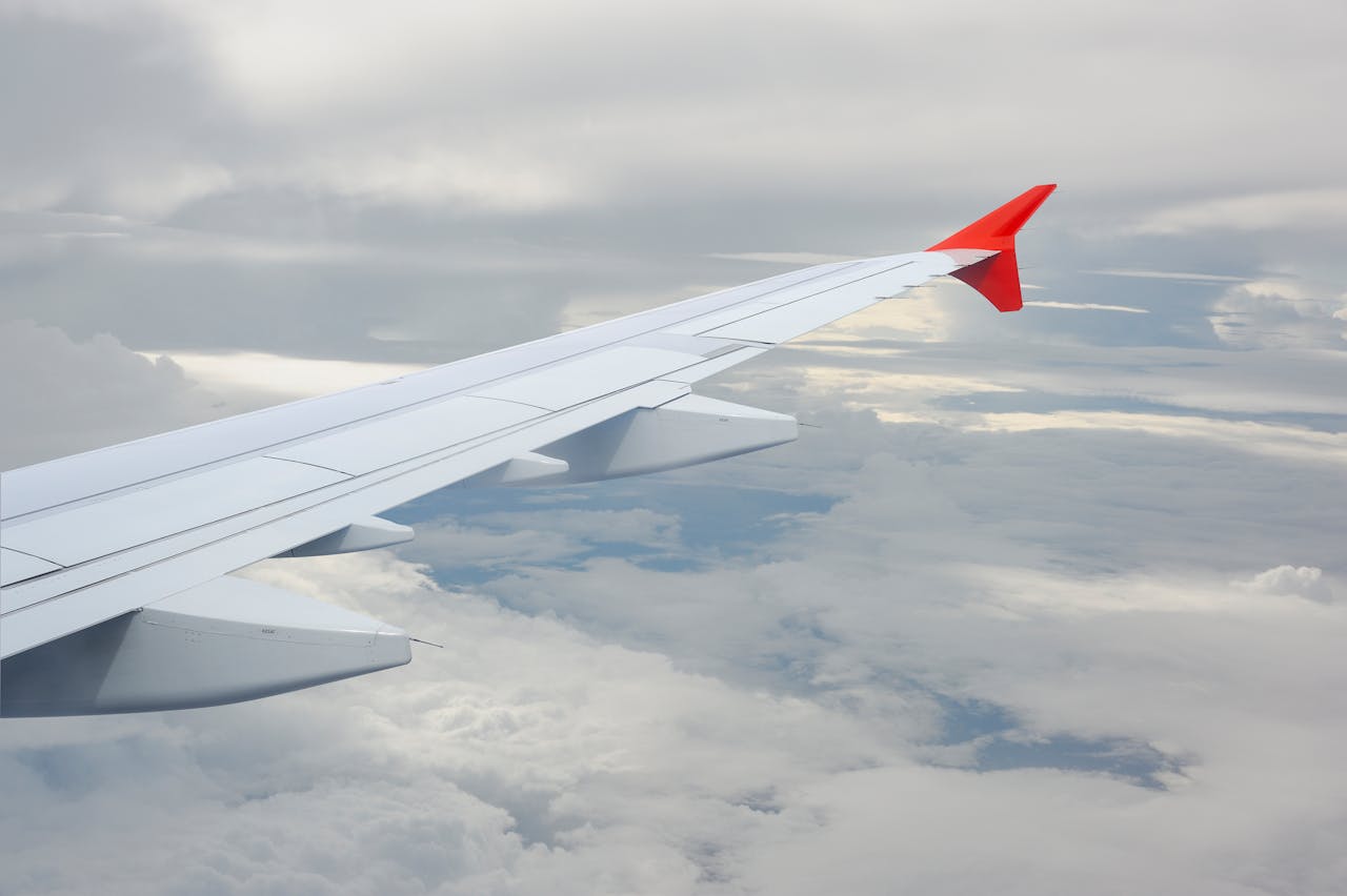 View from a plane window showing the wing against a cloudy sky.